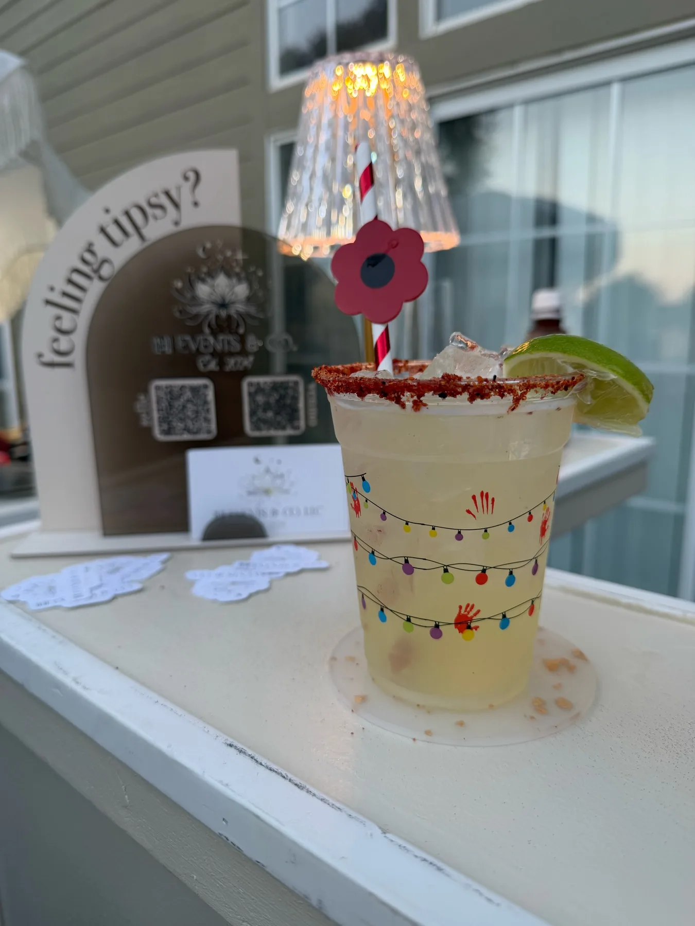 Pale signature cocktail with flower stirrer