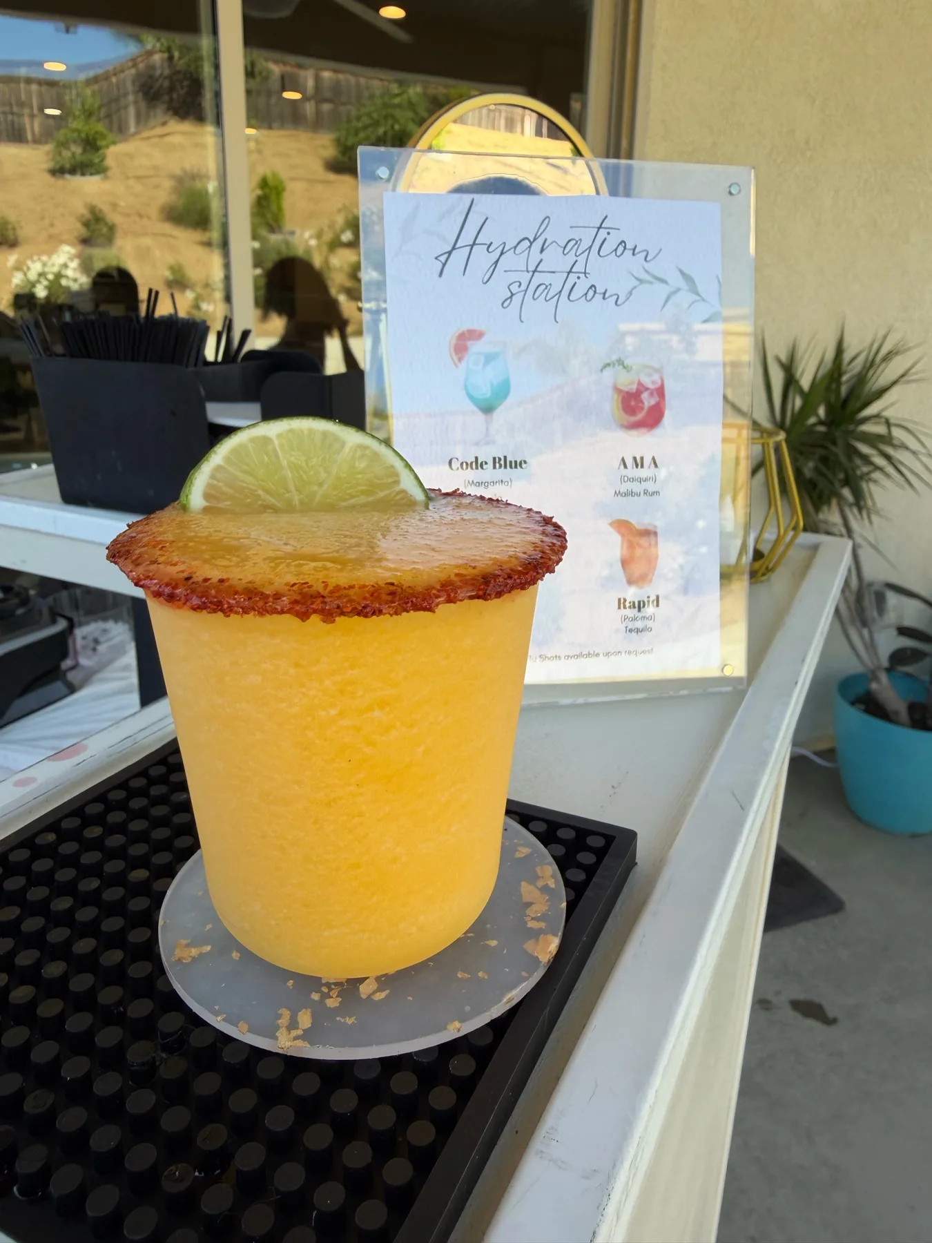 Orange cocktail in front of a hydration station menu